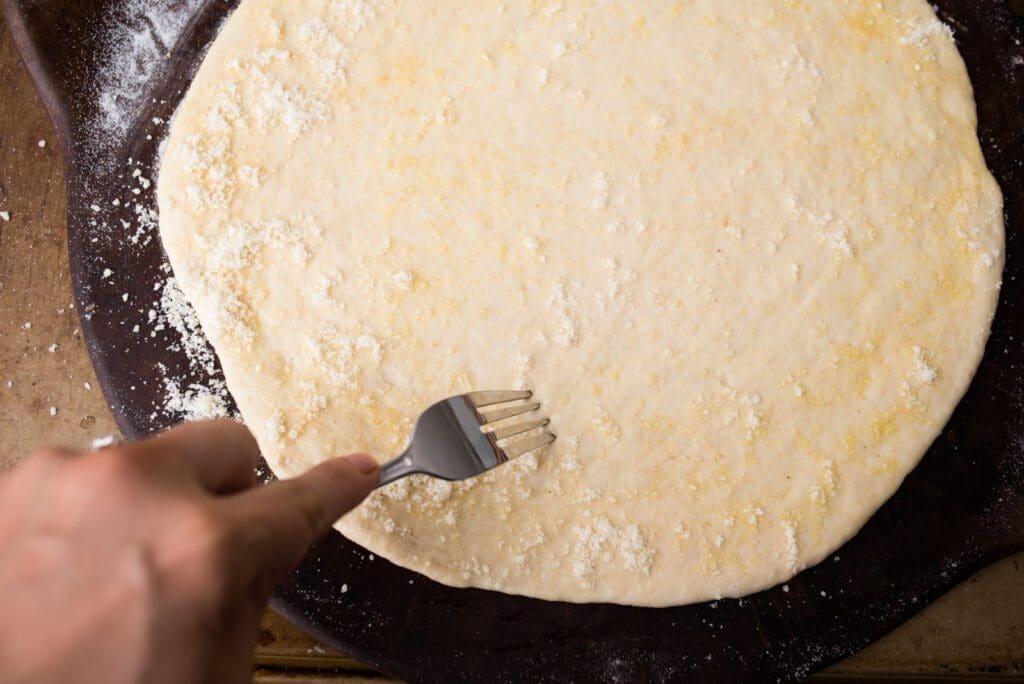 fork the rolled out quick-rise homemade pizza crust