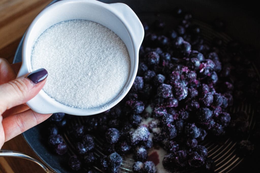 adding sugar to blueberries